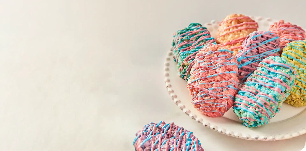 Colorful yarn-wrapped candies on a white plate with a light background
