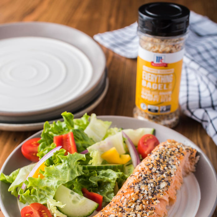 A plate of salmon with everything bagel seasoning, a side salad, and a jar of McCormick Everything Bagel Seasoning.