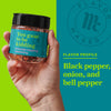 A hand holds a jar of Flavor Makers You Guac to be Kidding avocado topping seasoning, with the flavor profile listed as black pepper, onion, and bell pepper.