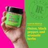 A hand holds a jar of Flavor Maker\'s I\'m Great in Bread seasoning, with a green background that says Flavor Profile: Onion, black pepper, and aromatic herbs.