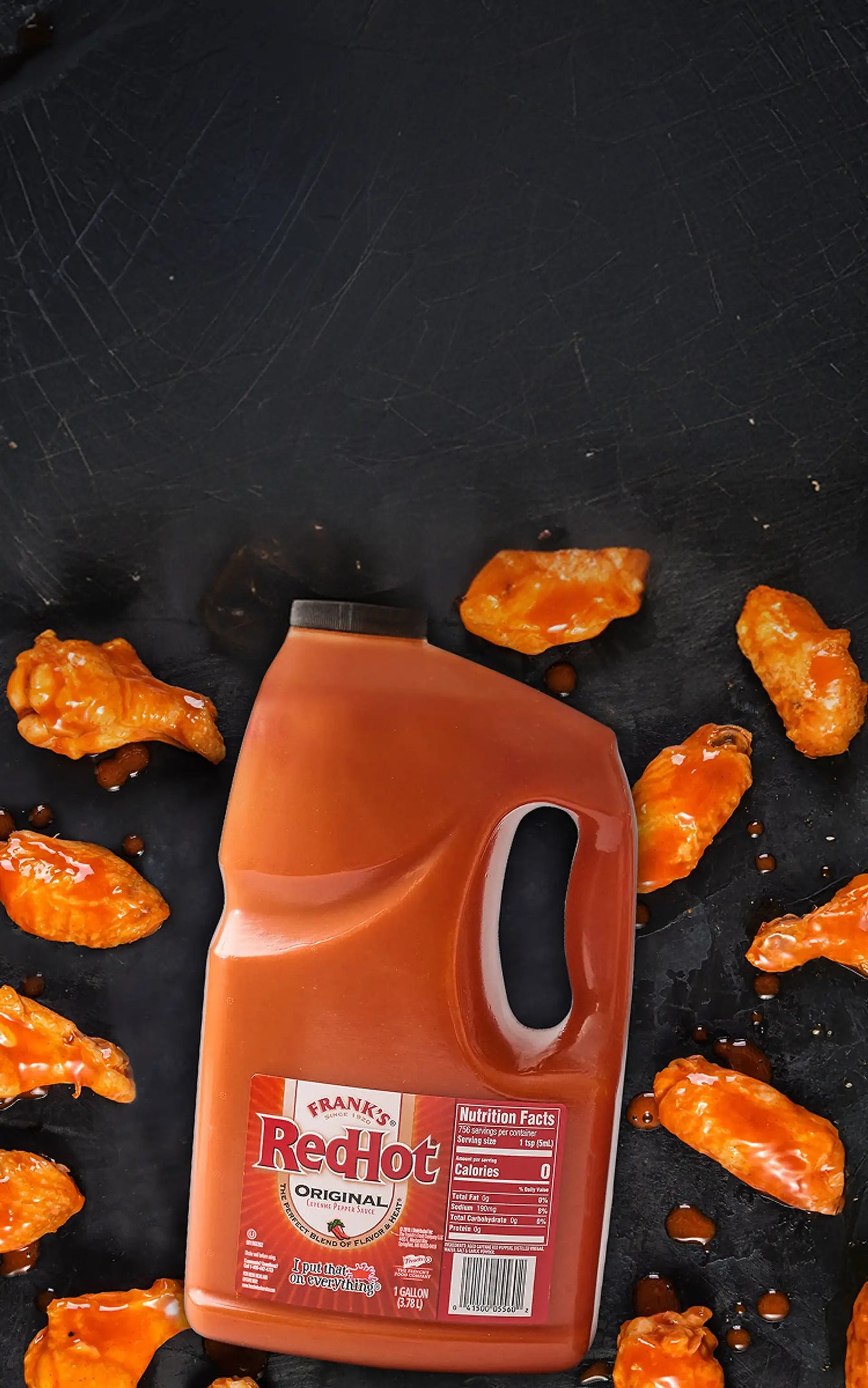 Frank's RedHot bottle with wings on a black surface