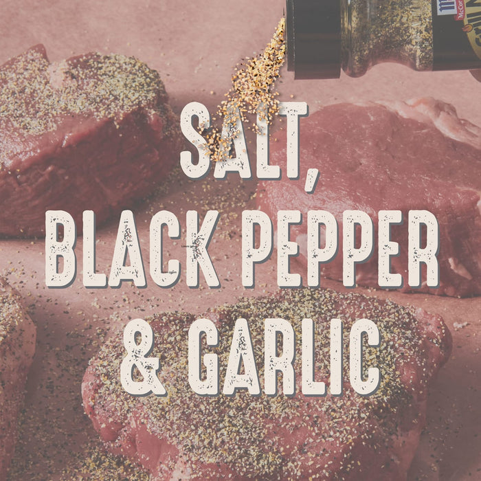 Salt, black pepper, and garlic are sprinkled on top of raw meat.