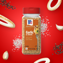 Jar of Garlic & Onion seasoning with red lid on a red background