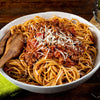 A bowl of spaghetti with meat sauce and parmesan cheese.