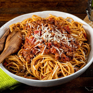 A bowl of spaghetti with meat sauce and parmesan cheese.