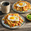 Two plates of breakfast hash with bacon, peppers, and a fried egg on top, seasoned with Mccormick Grill Mates Signature Blend Seasoning, 6.53 Oz, are served on a rustic wooden table with a steaming mug of coffee.