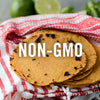 A stack of non-GMO corn tortillas on a red and white striped kitchen towel.