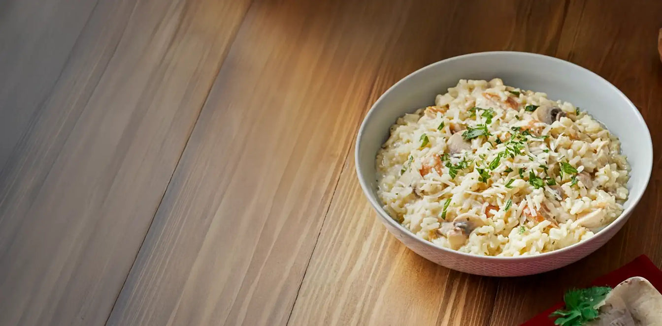Bowl of creamy risotto on a wooden table
