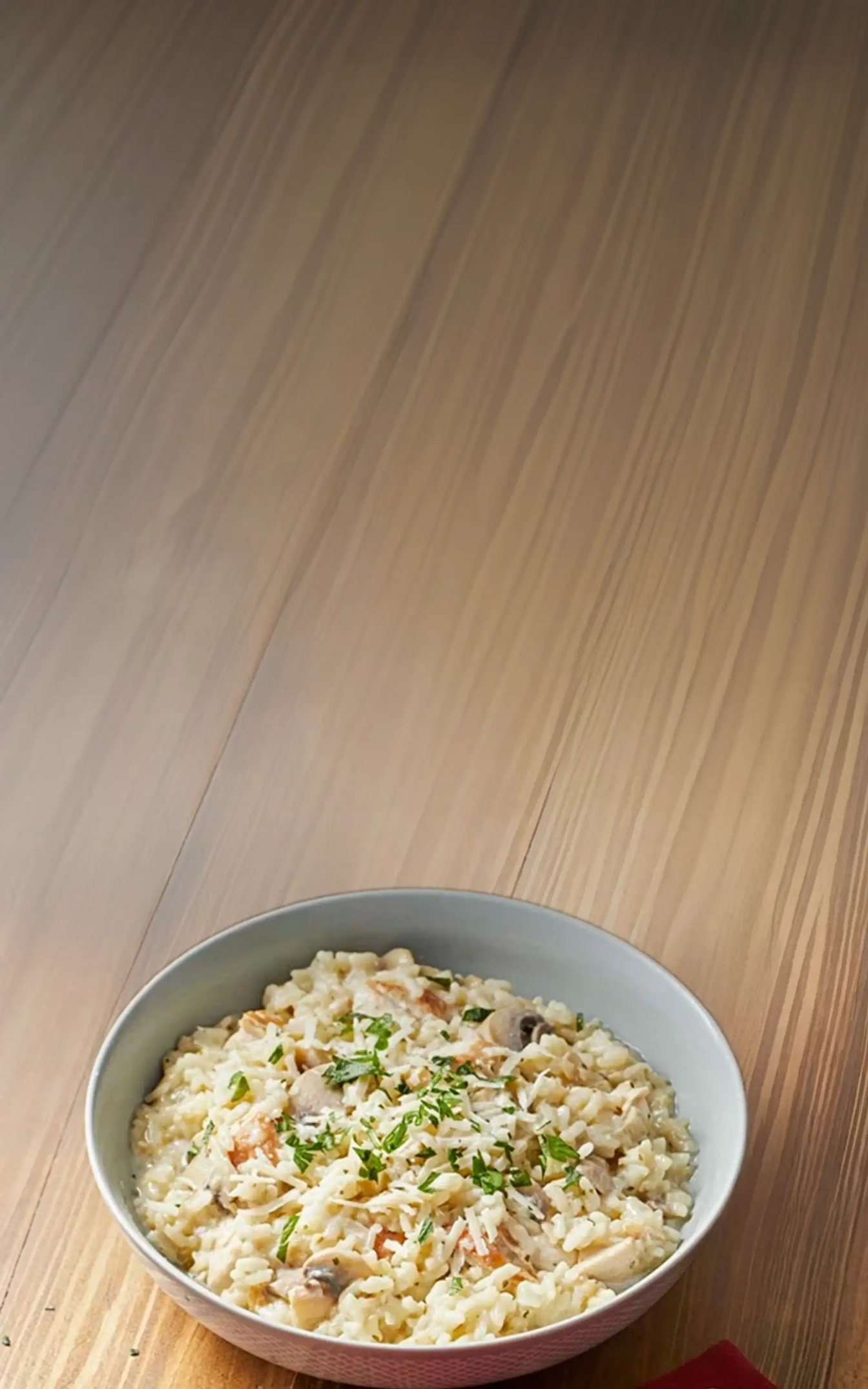 Bowl of creamy risotto on a wooden table