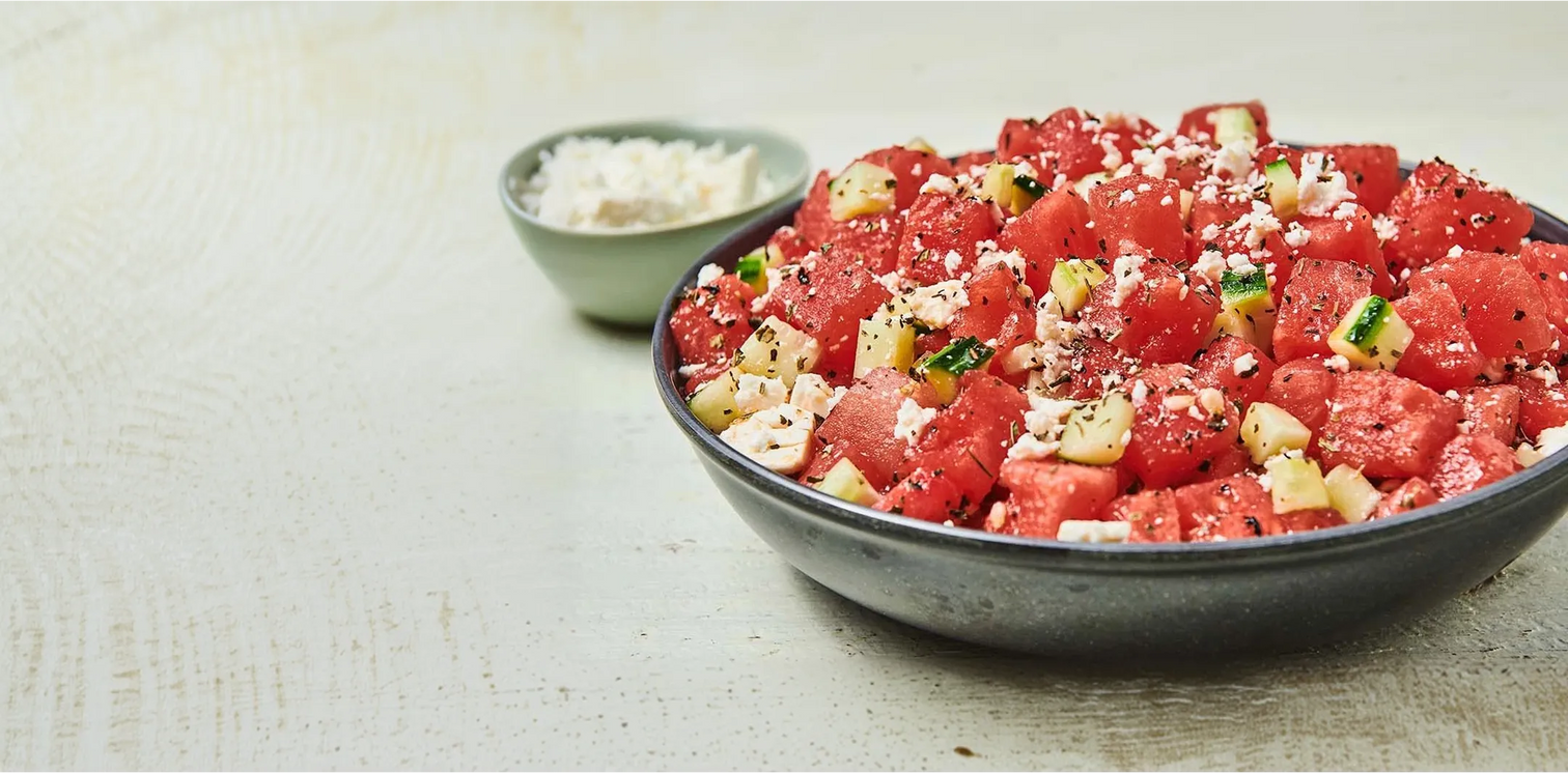 Bowl of watermelon salad with feta cheese on a light background
