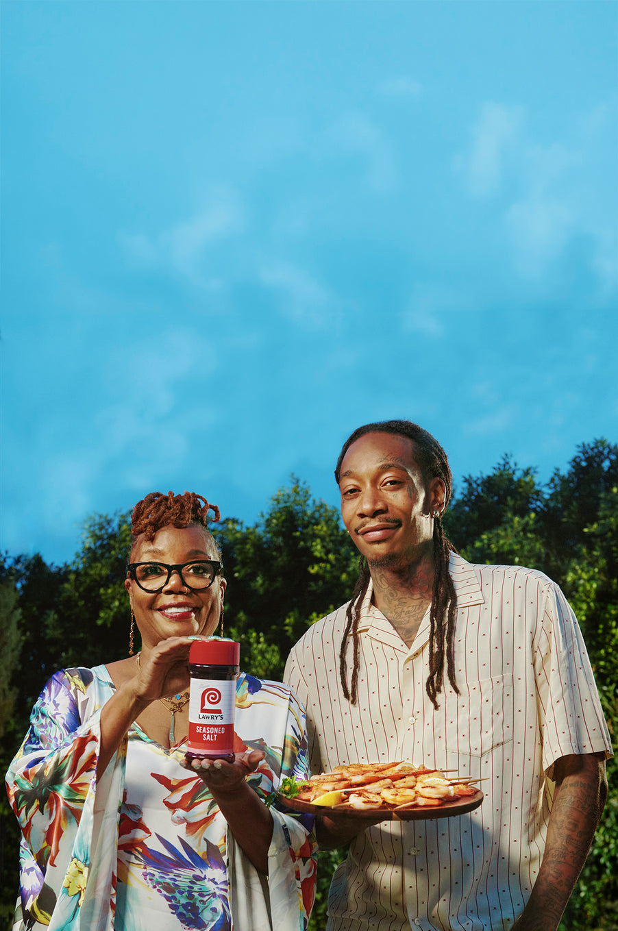 Wiz Khalifa and his Mom Peachie holding a Lawry's Seasoned Salt bottle and smiling
