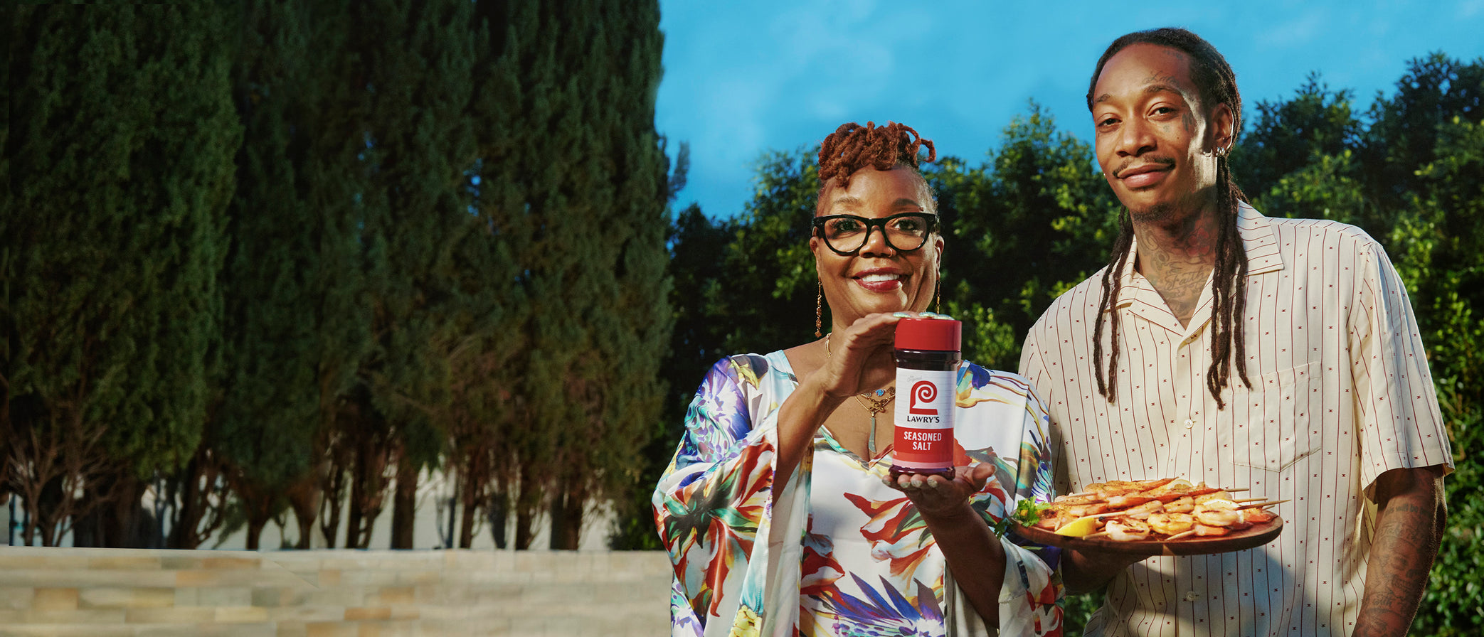 Wiz Khalifa and his Mom Peachie holding a Lawry's Seasoned Salt bottle and smiling