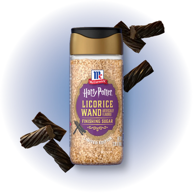 A jar of McCormick Harry Potter Licorice Wand Finishing Sugar surrounded by decorative dark licorice pieces on a white background with a soft blue glow.