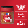 A jar of McCormick Mace Ground spice with a red background.