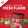 Two McCormick Poultry Seasoning jars with fresh herbs on a red background.