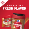 Two McCormick Pumpkin Pie Spice jars with a slice of pumpkin pie and cinnamon sticks.