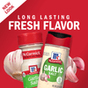 Two McCormick Garlic Salt containers with garlic cloves on a red background.
