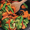 A close-up of a pan of stir-fried vegetables with sesame seeds.