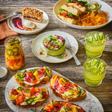 Assorted food items including sandwiches, salads, and drinks on a wooden table.