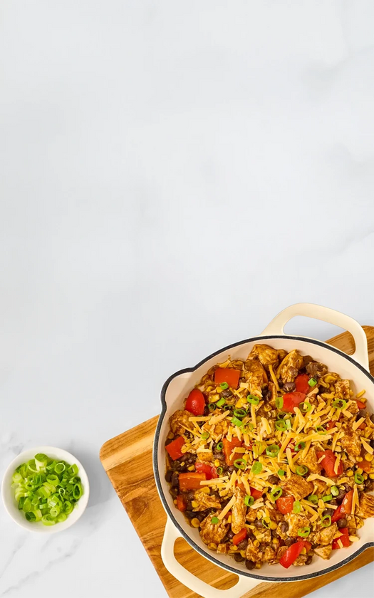 Dish of stir-fry with vegetables on a wooden board against a white background