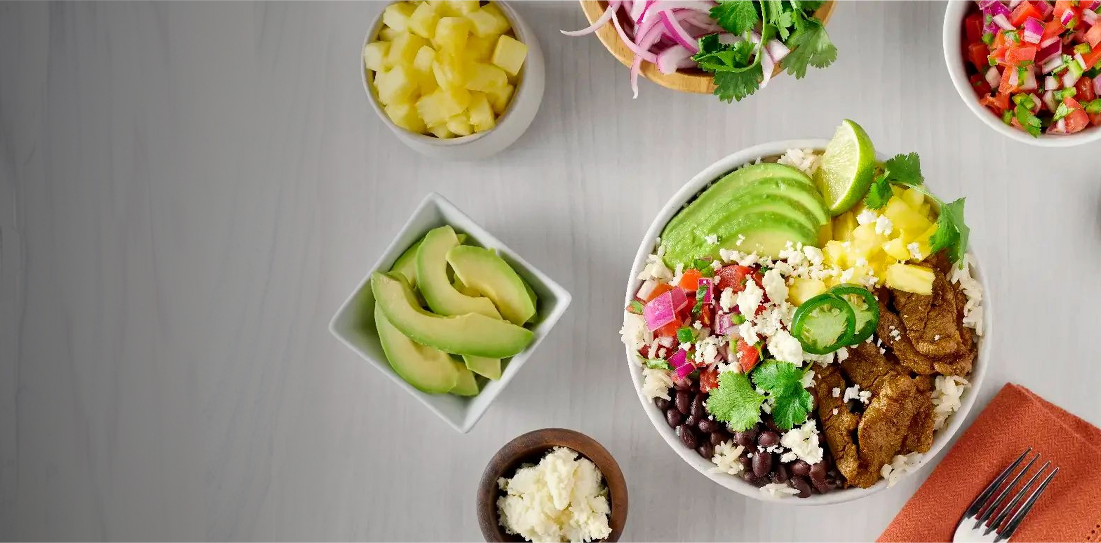 Colorful salad bowl with various ingredients on a gray surface