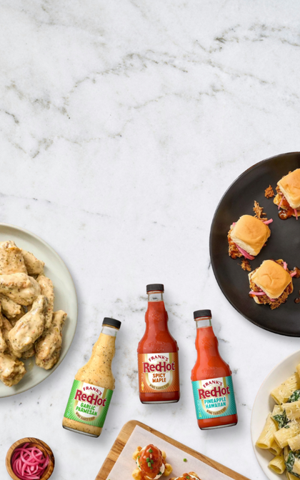 RedHot sauce bottles with food items on a marble surface