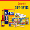 A collection of Old Bay seasoning products, including the classic seasoning, hot sauce, crab cake mix, and a wooden mallet, presented as a gift-giving idea.