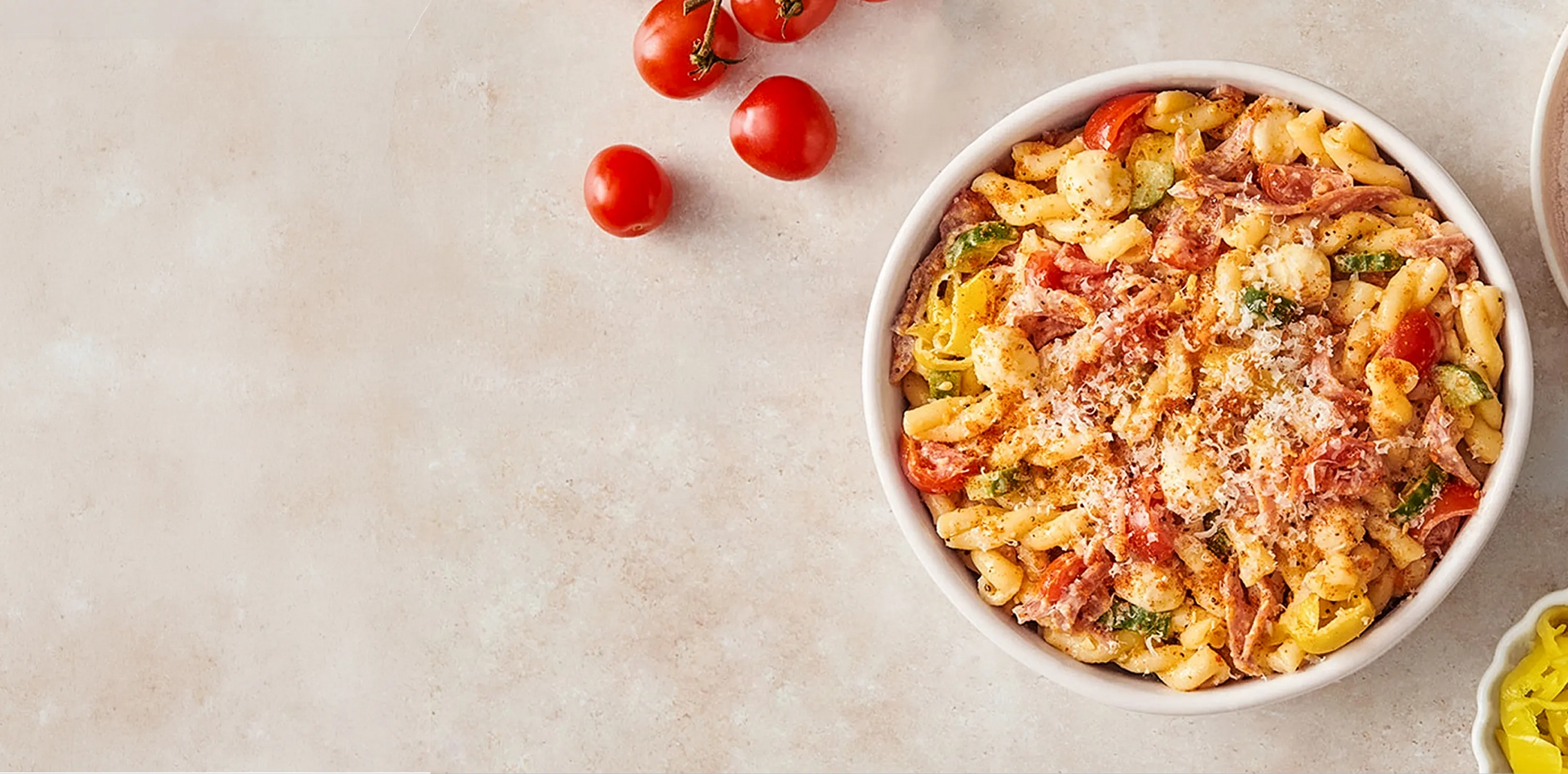  bowl of pasta with tomatoes on a light background