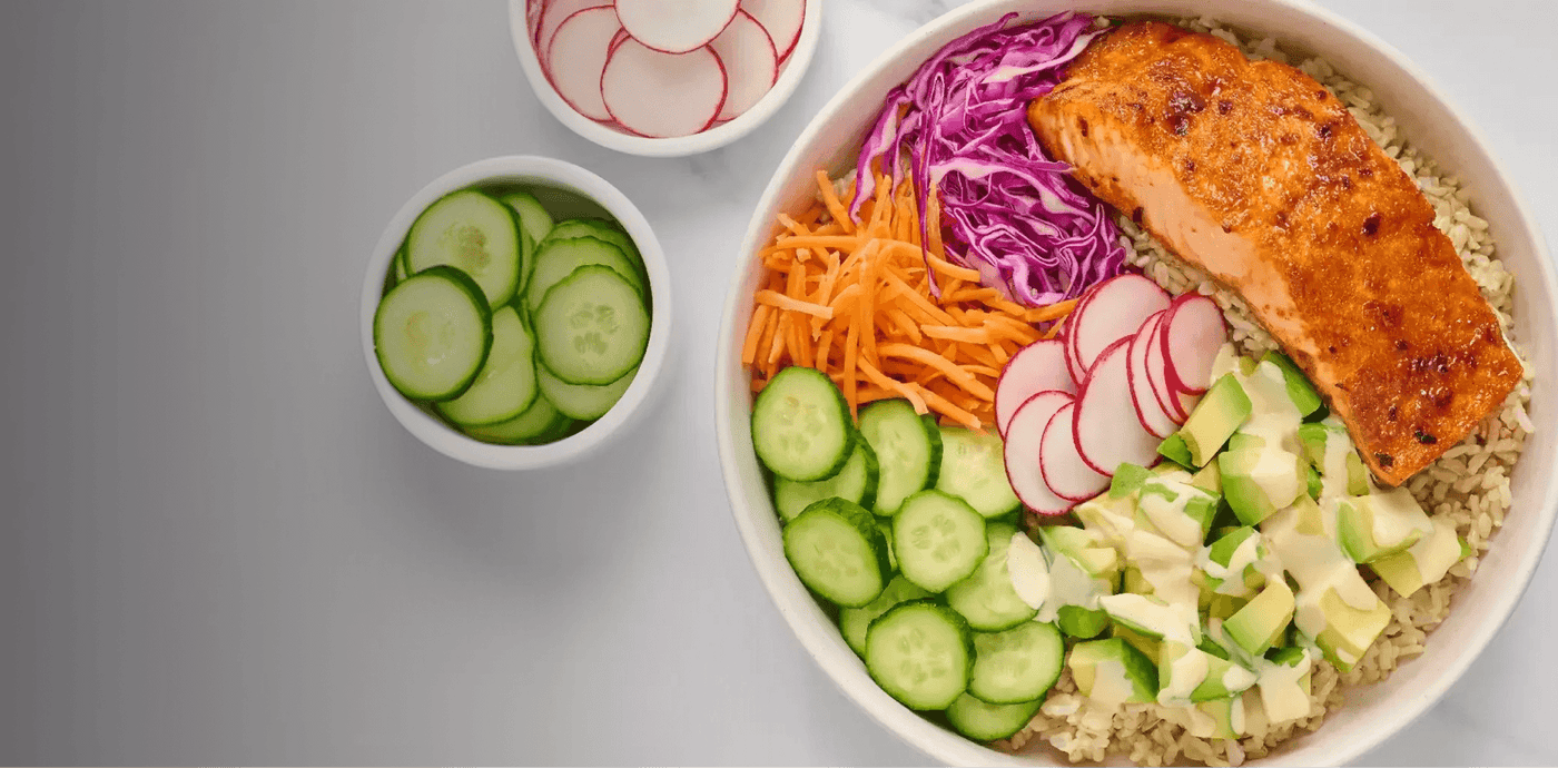Salmon bowl with vegetables on a gray background