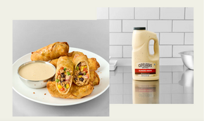 Egg rolls on a plate with dipping sauce and a bottle of Hidden Valley dressing on a tiled wall background.
