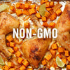 A close-up of a sheet pan with roasted chicken and sweet potatoes, with the words NON-GMO in the center.