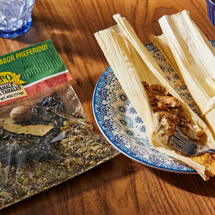 A bag of PoK brand tamale seasoning next to a plate of tamales.