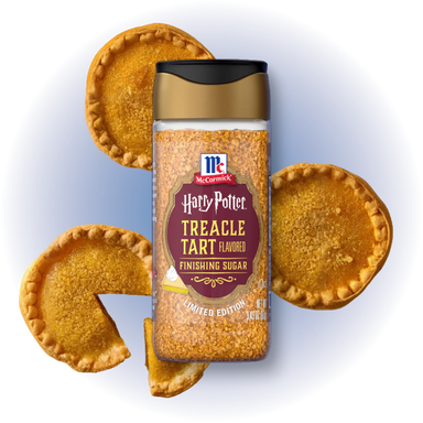 A jar of McCormick Harry Potter Treacle Tart Finishing Sugar centered on a white background with illustrated tart pie crusts around it.