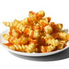 A plate of crispy french fries covered in a bright orange sauce.