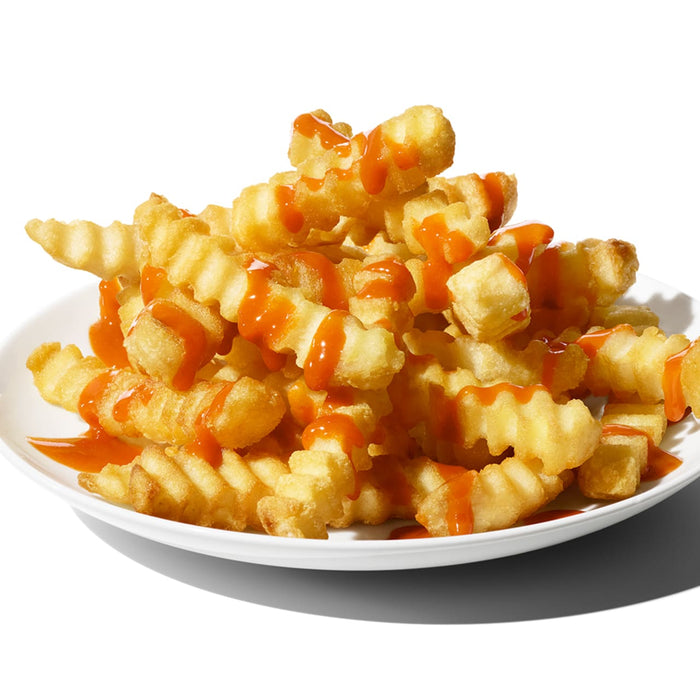 A plate of crispy french fries covered in a bright orange sauce.