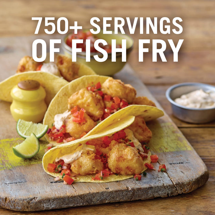 A close-up of a wooden cutting board with three fish tacos, a yellow salt shaker, and a bowl of dipping sauce.