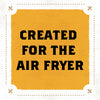 A yellow sign with a black border and fleur-de-lis in the corners reads Created for the Air Fryer.