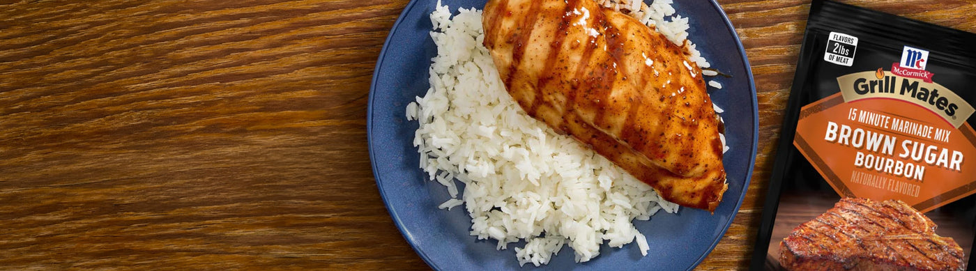 Plate of chicken breast with rice and a package of Grill Mates seasoning on a wooden table