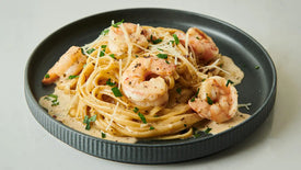 Platter of spaghetti with shrimp on a light background