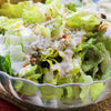 A bowl of Caesar salad with croutons, parmesan cheese, and dressing.