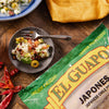 A bag of El Guapo Japanese Chile Powder sits on a wooden table next to a bowl of ceviche.