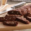 Chocolate biscotti with white chocolate chips are sliced on a wooden cutting board.
