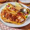 A plate of fish tacos with salsa and avocado.