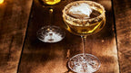 Two cocktails in martini glasses on a wooden surface