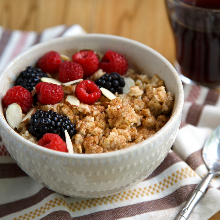 A bowl of oatmeal topped with berries and almonds.
