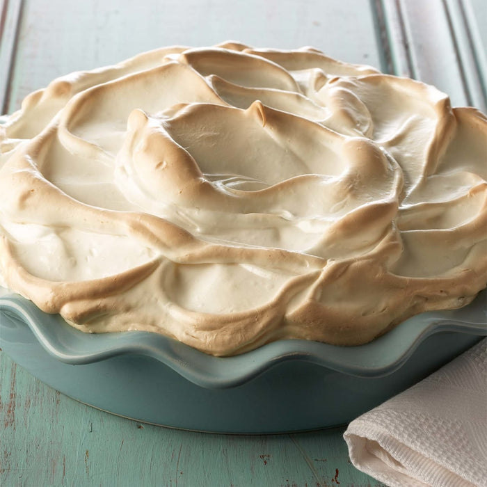 A close-up of a meringue pie in a blue pie dish.