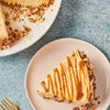 A slice of caramel pretzel cheesecake on a pink plate.