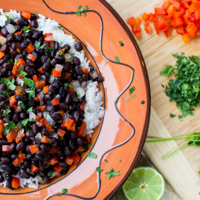 A plate of black beans, rice, red peppers, and cilantro.