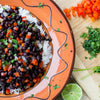 A plate of black beans, rice, red peppers, and cilantro.