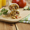 A burrito cut in half and stacked on top of each other, showcasing the filling of rice, meat, and vegetables.